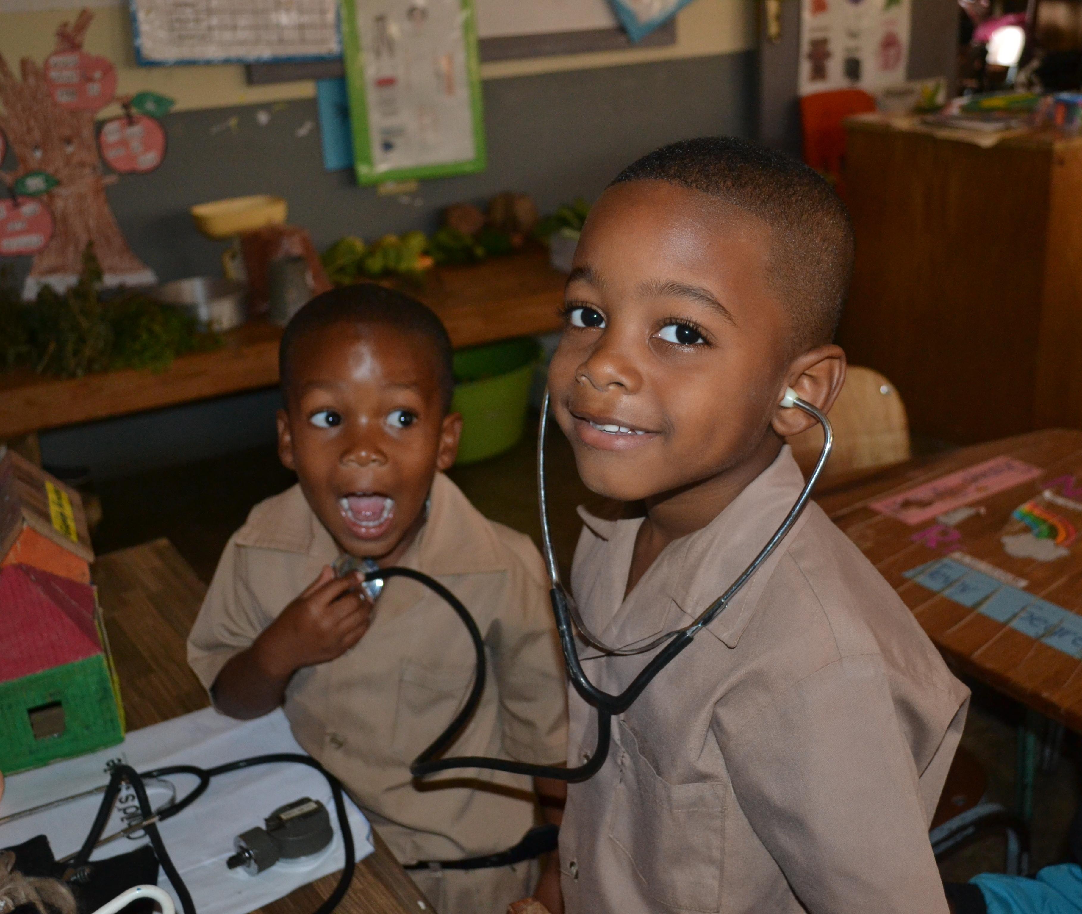 Two young children play with medical equipment in a Care centre during an Outreach programme in Jamaica. Young boys play doctor during a Medical Outreach ran by Dentistry interns during a Dentistry placement in Jamaica.